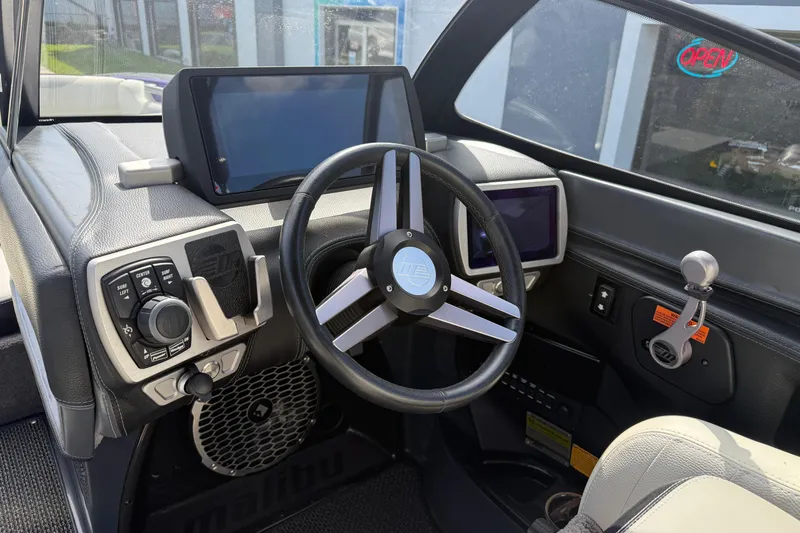 Slide: The Image of 2015 Malibu Wakesetter 24 MXZ boat dashboard with steering wheel and control panel. - 21