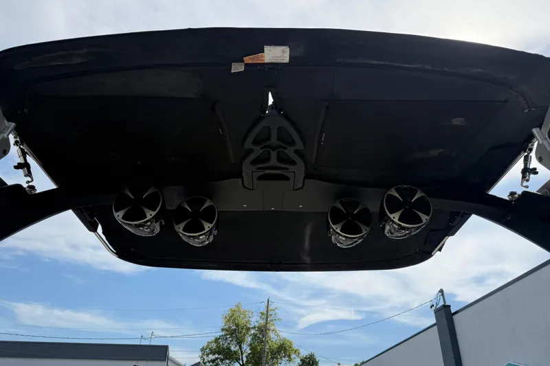 Slide: The Image of 2015 Malibu Wakesetter 24 MXZ boat speakers under canopy, clear sky background. - 28