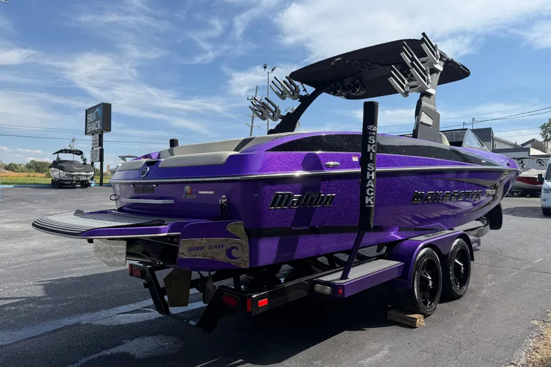 Slide: The Image of 2015 Malibu Wakesetter 24 MXZ boat in vibrant purple, parked on a trailer at a dealership. - 6