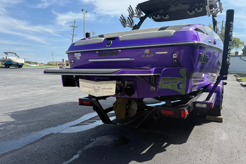 Slide: The Image of 2015 Malibu Wakesetter 24 MXZ boat in vibrant purple on a trailer. - 7