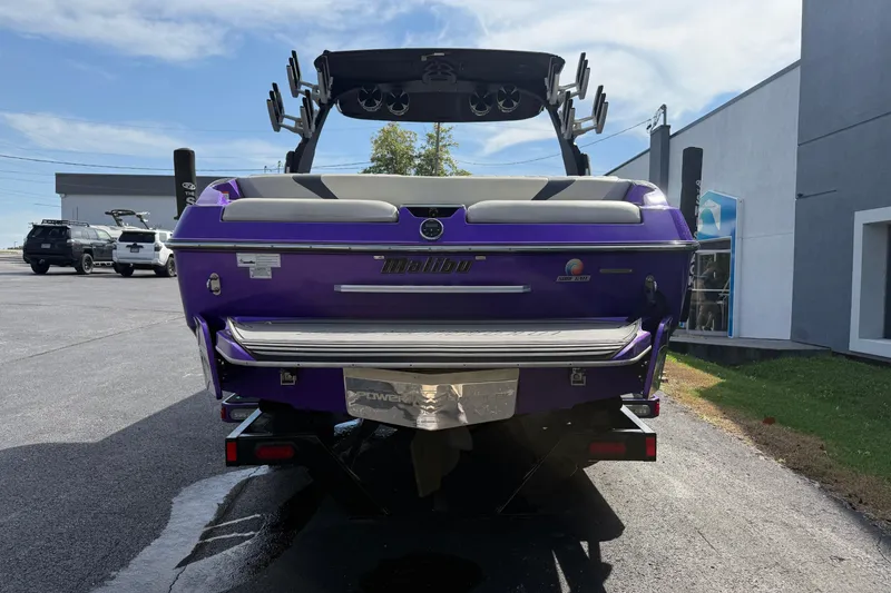 Slide: The Image of 2015 Malibu Wakesetter 24 MXZ boat, purple exterior, parked outdoors. - 8