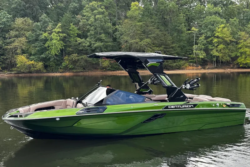 Slide: The Image of 2026 Centurion Ri245 boat in vibrant green on a serene lake, surrounded by lush trees. - 10