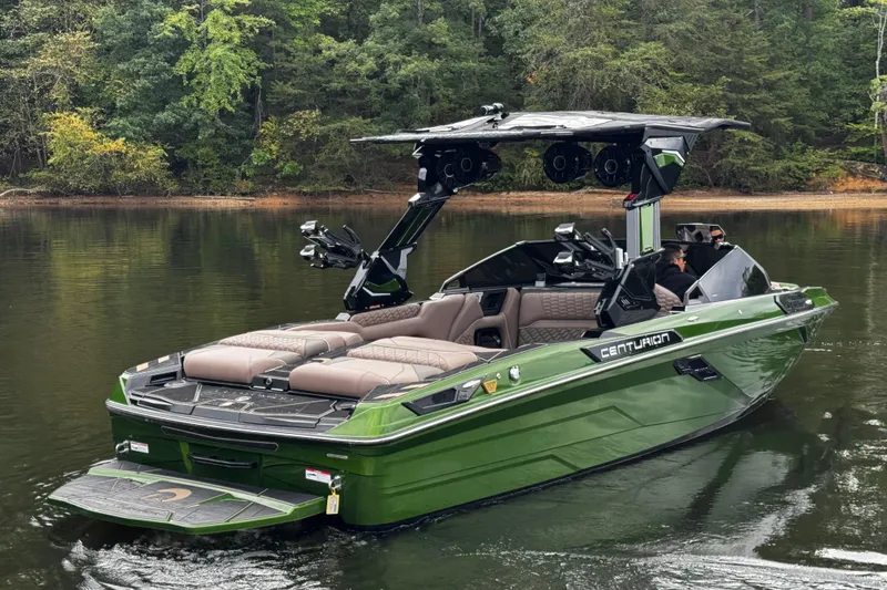 Slide: The Image of 2026 Centurion Ri245 boat in green on a calm lake, surrounded by trees. - 6