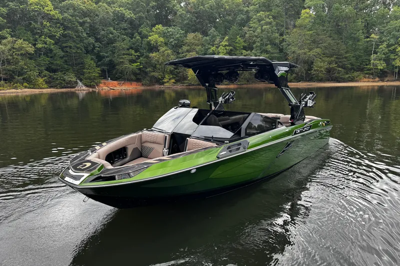 Slide: The Image of 2026 Centurion Ri245 boat in a serene lake setting, surrounded by lush trees. - 8