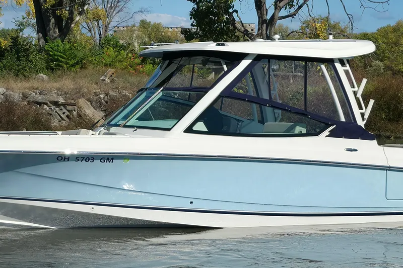 Slide: The Image of 2024 Boston Whaler 280 Vantage boat on water, side view with trees in background. - 2