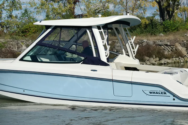Slide: The Image of 2024 Boston Whaler 280 Vantage boat cruising on a calm waterway. - 4