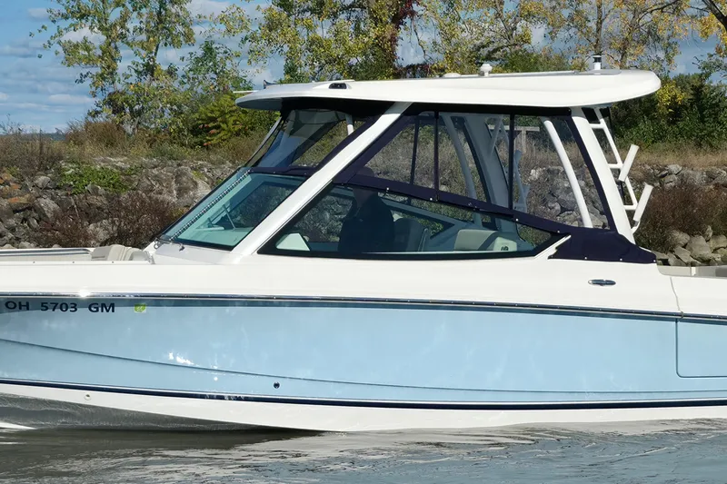 Slide: The Image of 2024 Boston Whaler 280 Vantage boat on water, side view with trees in background. - 5