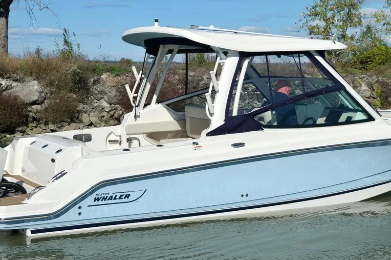 Slide: The Image of 2024 Boston Whaler 280 Vantage boat cruising on a calm waterway. - 8
