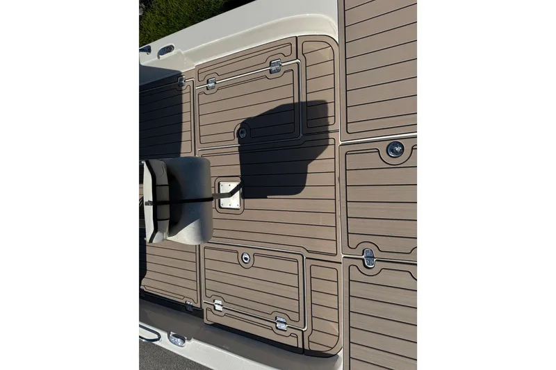 Slide: The Image of 2020 Carolina Skiff 21 LS DC boat deck with tan non-slip surface and storage compartments. - 29