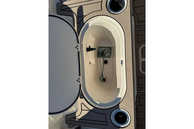 Slide: The Image of Livewell compartment on a 2020 Carolina Skiff 21 LS DC boat, featuring a net and drain. - 45