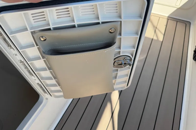 Slide: The Image of 2020 Carolina Skiff 21 LS DC boat storage compartment with latch and beige pocket. - 51