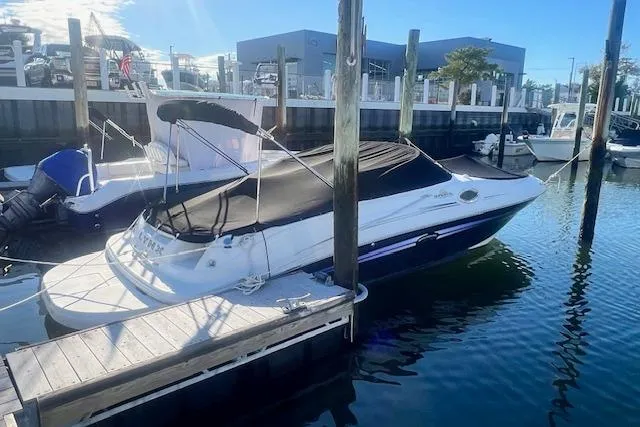 The Image of 2007 Sea Ray 240 Sundeck boat docked with cover in sunny marina. - 0