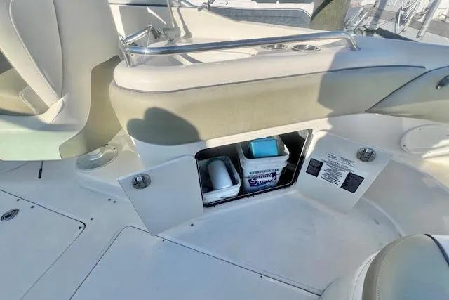 Slide: The Image of 2007 Sea Ray 240 Sundeck interior storage compartment with open hatch, revealing stored items. - 10