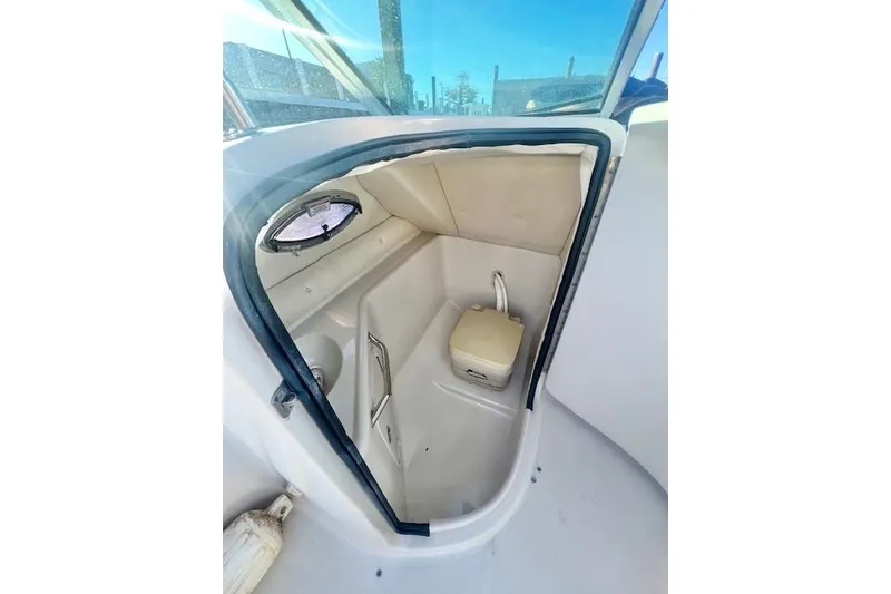 Slide: The Image of 2007 Sea Ray 240 Sundeck interior cabin with compact toilet and window. - 16
