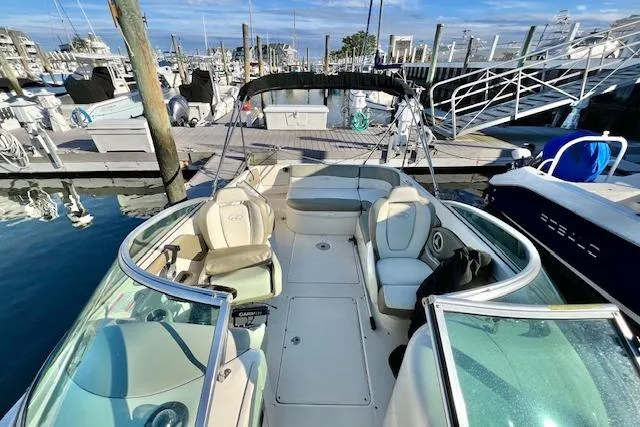 Slide: The Image of 2007 Sea Ray 240 Sundeck boat docked at marina, featuring spacious seating and clear skies. - 8