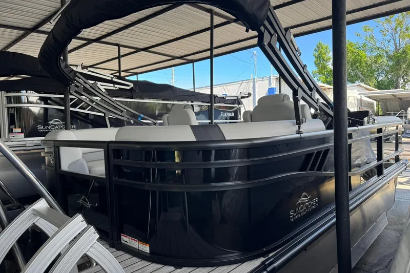 Slide: The Image of 2025 SunCatcher Select 320 RC pontoon boat under a covered dock. - 2