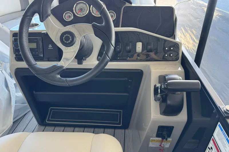 Slide: The Image of 2025 SunCatcher Select 320 RC boat dashboard with steering wheel and control panel. - 4