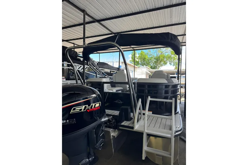 Slide: The Image of 2025 SunCatcher Select 320 RC pontoon boat with Yamaha SHO VMAX engine, docked under shelter. - 5