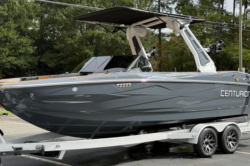 Slide: The Image of 2026 Centurion Nv233 boat on trailer, sleek design, gray color, parked outdoors. - 14