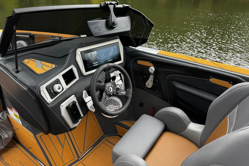 Slide: The Image of 2026 Centurion Nv233 boat interior with modern dashboard and steering wheel on a calm lake. - 20