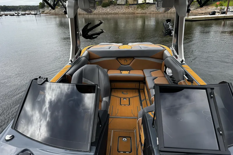 Slide: The Image of 2026 Centurion Nv233 boat interior with luxurious seating and sleek design on a calm lake. - 22