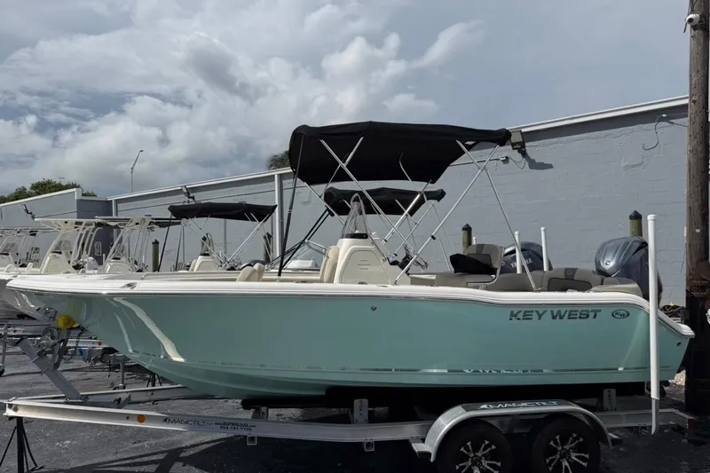 The Image of 2026 Key West 203 FS boat with canopy on trailer, parked outdoors. - 0
