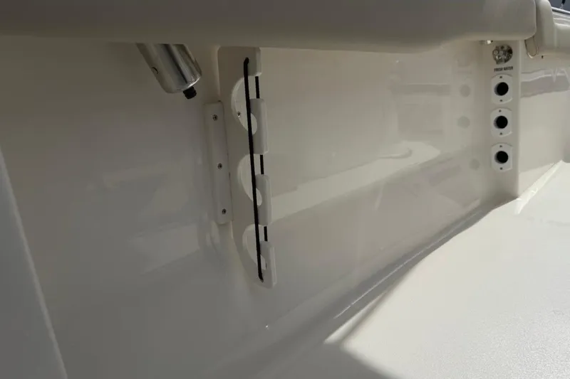 Slide: The Image of 2026 Key West 203 FS boat interior detail with rod holders and fresh water outlets. - 25