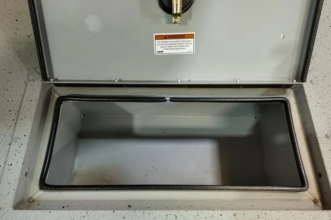 Slide: The Image of Open storage compartment in 2024 SeaArk Shadow 18 t boat, featuring a warning label. - 16