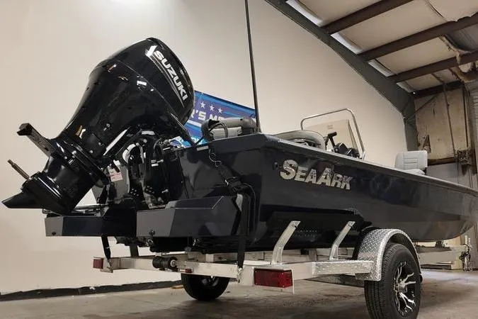 Slide: The Image of 2024 SeaArk Shadow 18 t boat with Suzuki engine on trailer in warehouse. - 2