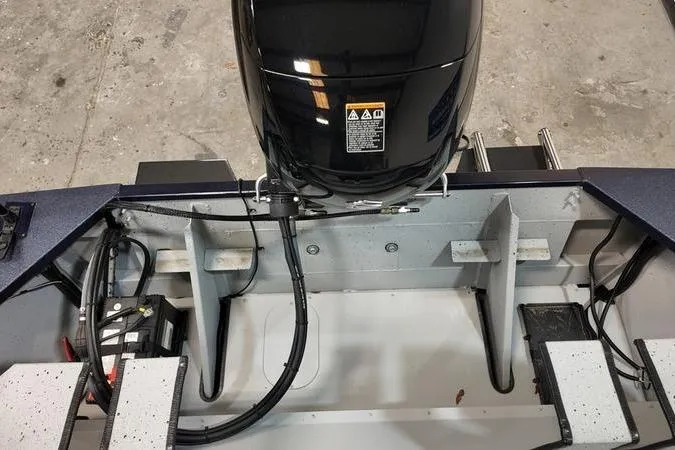 Slide: The Image of 2024 SeaArk Shadow 18 t boat engine compartment with visible wiring and components. - 4