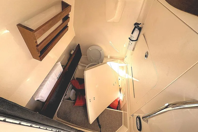 Slide: The Image of 2021 Grady-White Canyon 271 boat interior with storage, toilet, and safety equipment. - 16