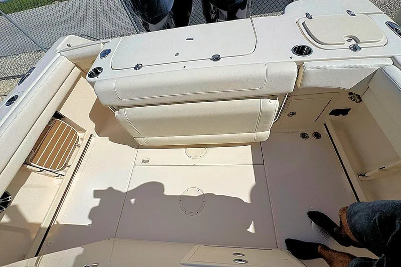 Slide: The Image of 2021 Grady-White Canyon 271 boat interior with beige seating and storage compartments. - 7