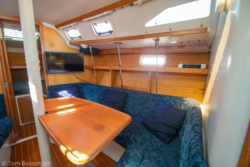Slide: The Image of Interior of a 1997 Catalina 320 MkII sailboat with cozy seating and a mounted TV. - 17