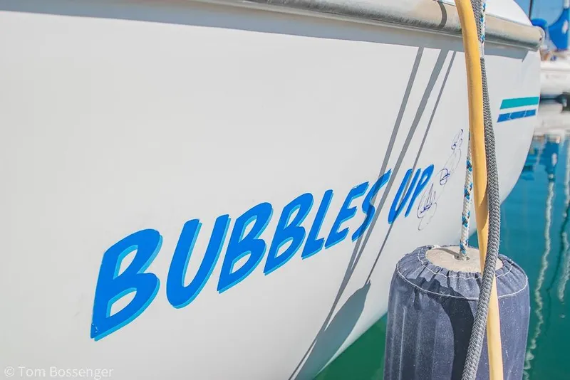 Slide: The Image of Catalina 320 MkII sailboat named "Bubbles Up" docked, featuring blue lettering and nautical fender. - 4