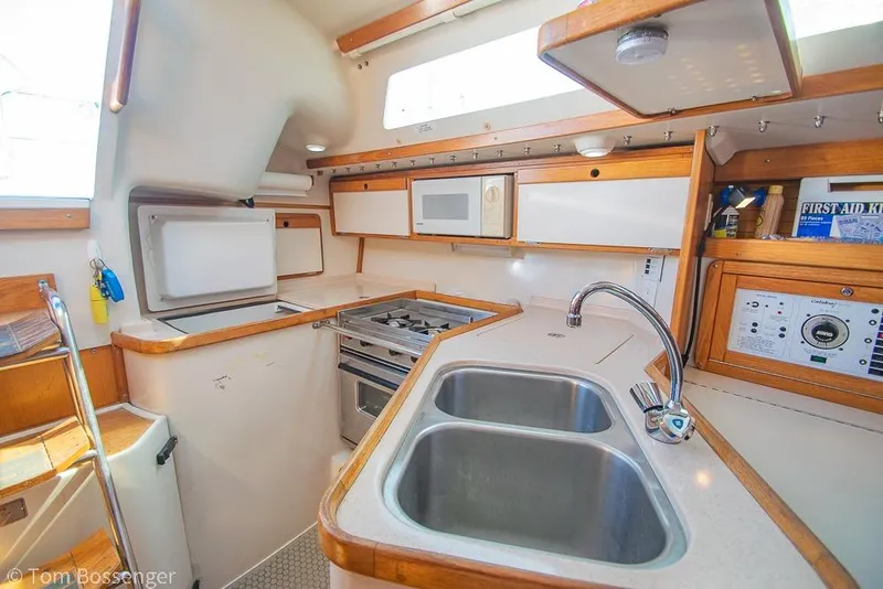 Slide: The Image of 1997 Catalina 320 MkII yacht kitchen with dual sink, stove, and microwave. - 8