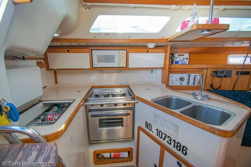 Slide: The Image of Interior of 1997 Catalina 320 MkII sailboat kitchen with stove, sink, and storage. - 9