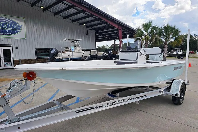 Slide: The Image of 2026 Sea Pro 172 Bay boat on trailer at dealership, under a covered area. - 2