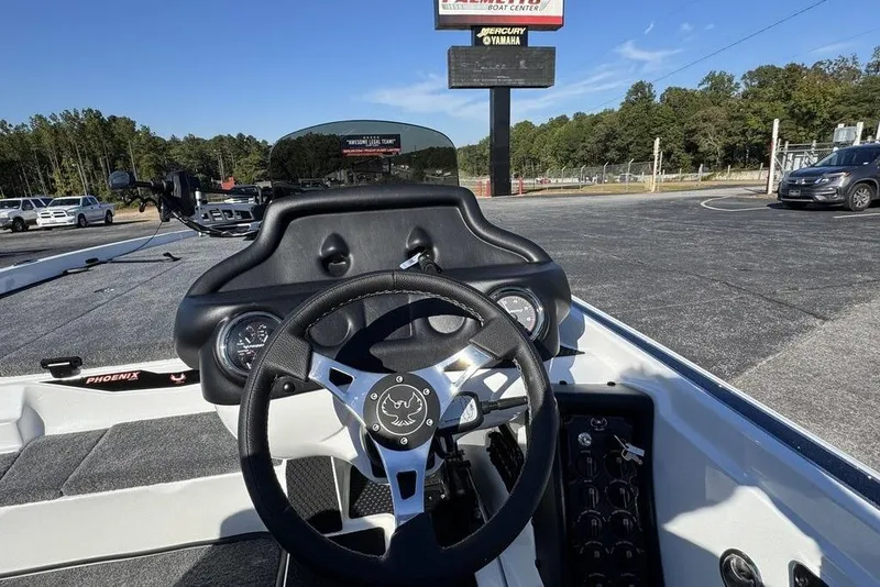 Slide: The Image of 2026 Phoenix 721 ZXL boat dashboard with steering wheel and controls in outdoor setting. - 14