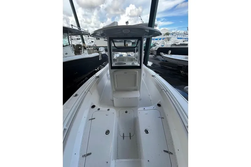 Slide: The Image of 2023 Seahunt SXS boat interior with center console and open deck, under cloudy sky. - 10