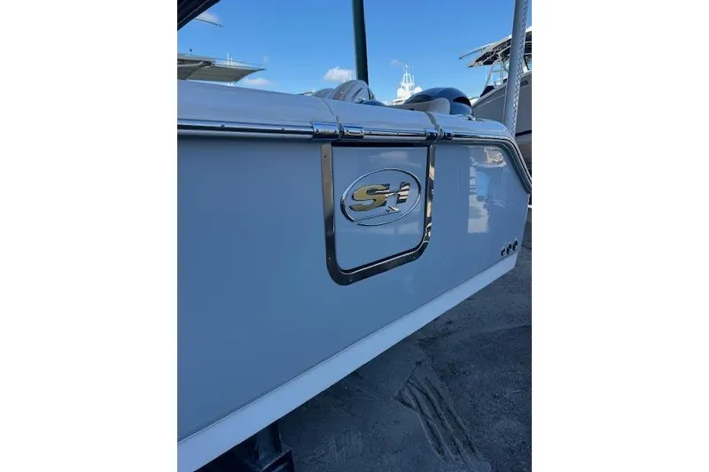 Slide: The Image of 2023 Sea Hunt Ultra 265 SE boat, rear view with logo, docked outdoors. - 14