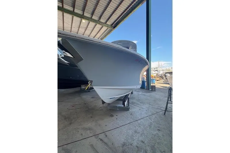 Slide: The Image of 2023 Sea Hunt Ultra 265 SE boat in a covered marina, side view. - 15