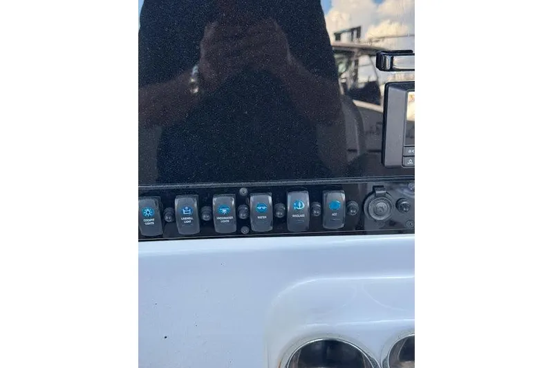 Slide: The Image of Control panel of 2023 Sea Hunt Ultra 265 SE boat with various switches. - 22