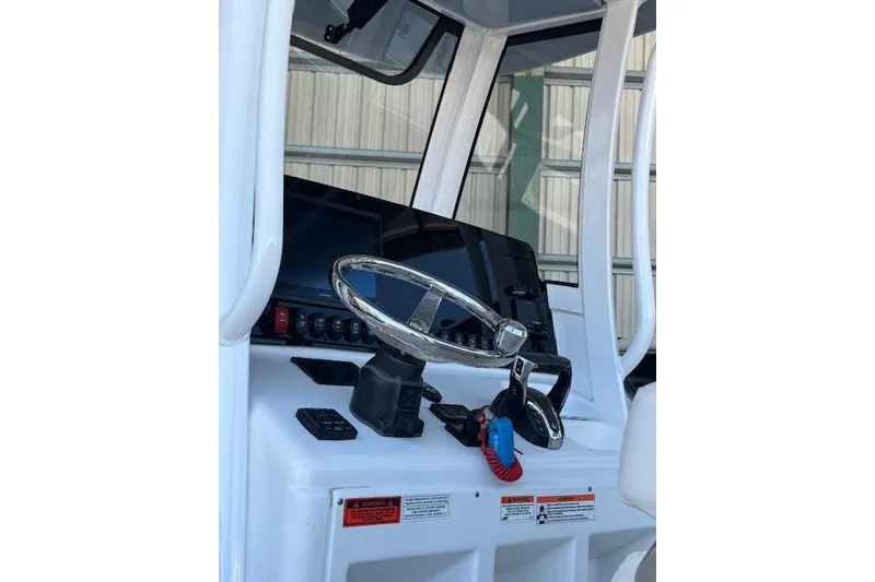 Slide: The Image of 2023 Sea Hunt Ultra 265 SE boat dashboard with steering wheel and controls. - 24