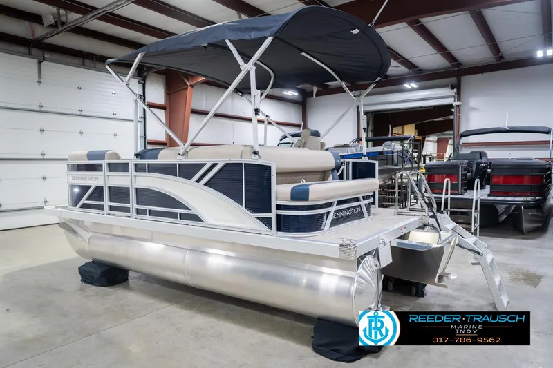 Slide: The Image of 2026 Bennington 168 SLJ pontoon boat in showroom with canopy and seating. - 10