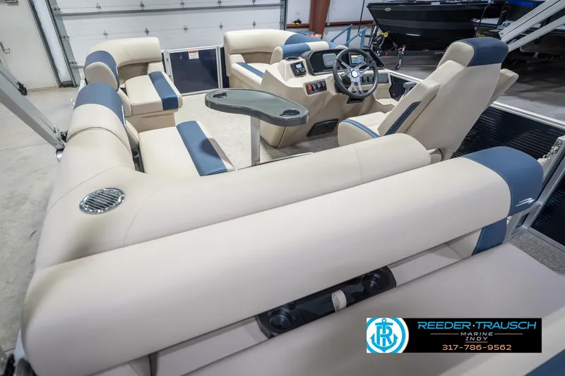 Slide: The Image of 2026 Bennington 168 SLJ pontoon boat interior with beige and blue seating, steering console, and table. - 15