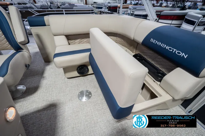 Slide: The Image of 2026 Bennington 168 SLJ boat interior with beige and blue seating, cup holders, and storage. - 25