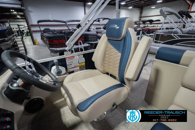Slide: The Image of 2026 Bennington 168 SLJ boat interior with beige and blue seating in showroom. - 27