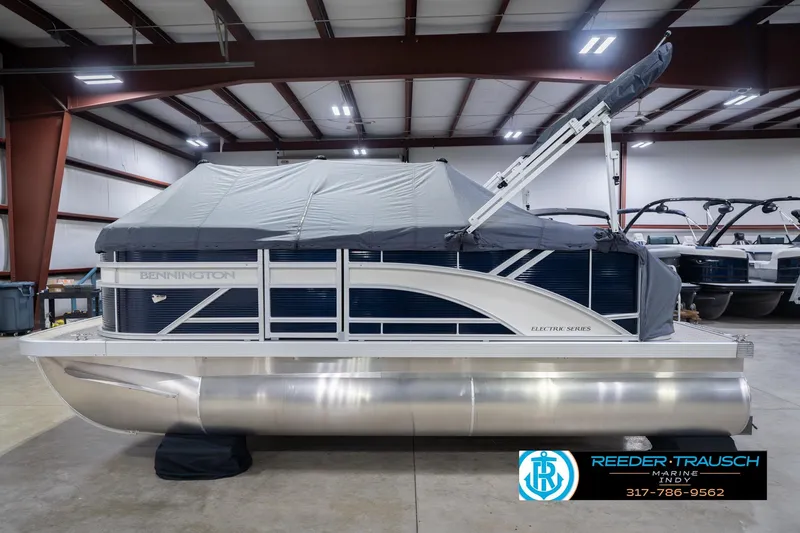 Slide: The Image of 2026 Bennington 168 SLJ pontoon boat in a showroom, covered and ready for display. - 52