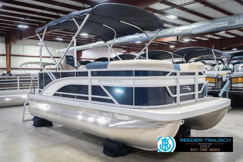 Slide: The Image of 2026 Bennington 168 SLJ pontoon boat in showroom, featuring sleek design and canopy. - 6