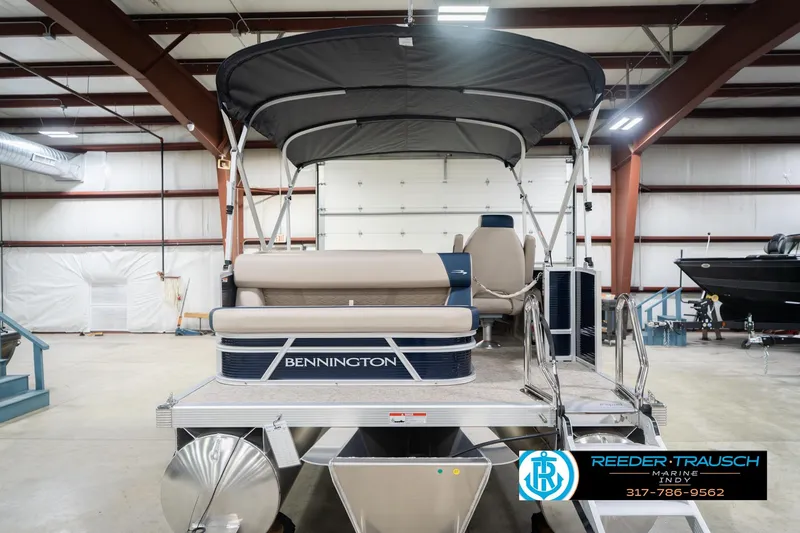 Slide: The Image of 2026 Bennington 168 SLJ pontoon boat in a showroom, featuring a canopy and seating. - 9